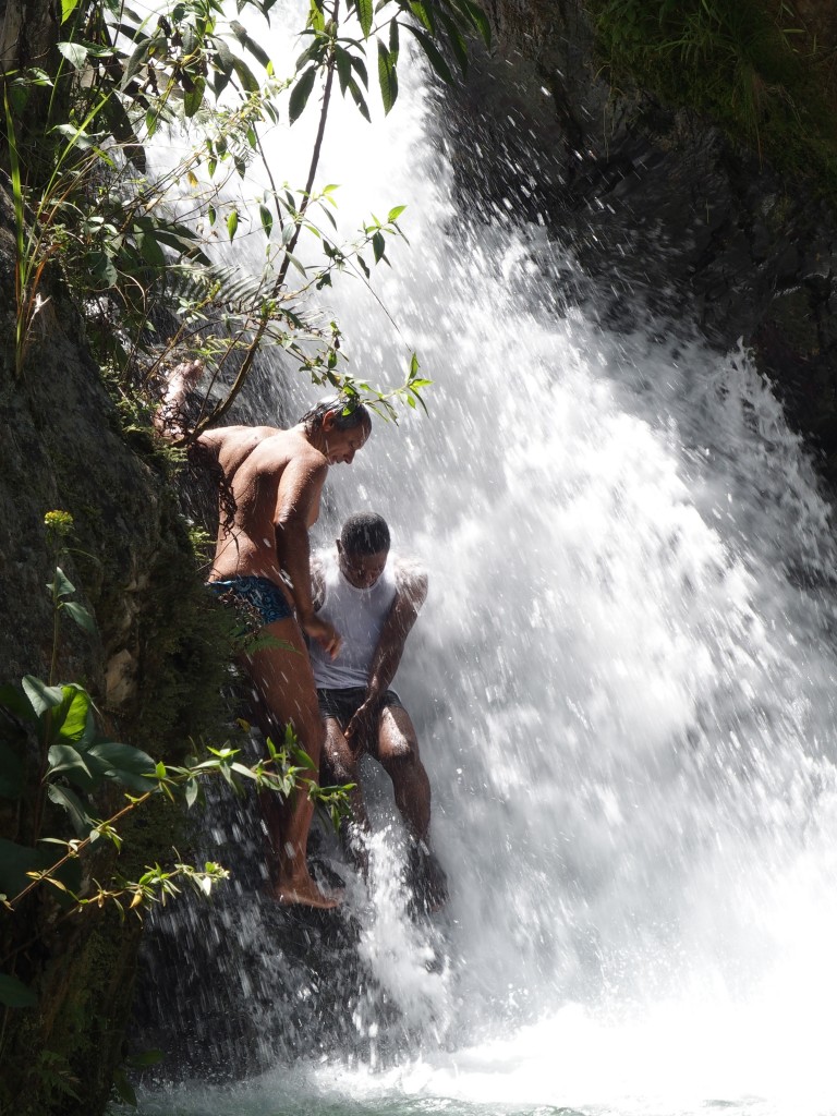 Two adventurers climb into the waterfalls.